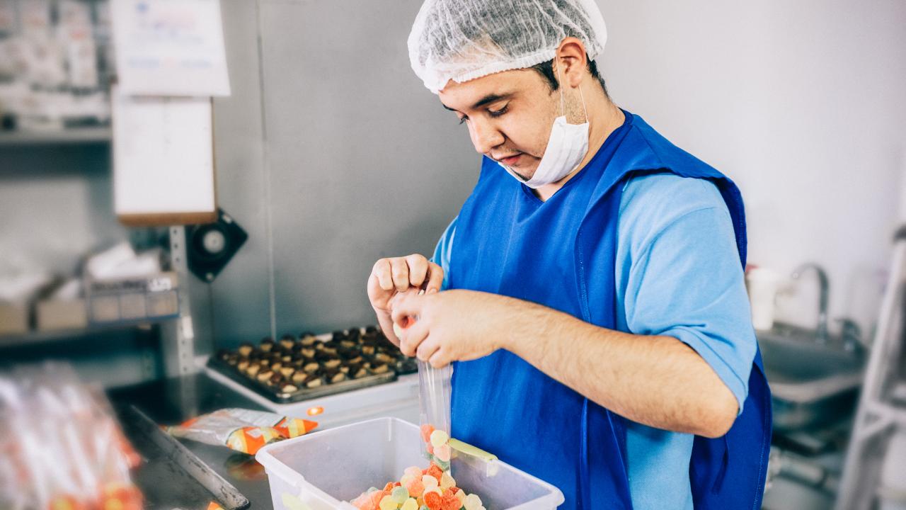 A man with developmental disabilities working at a candy store