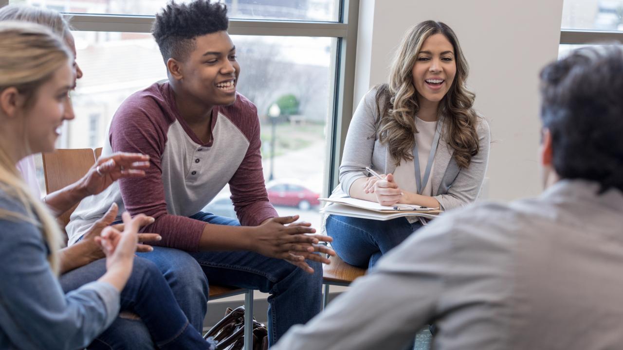 A group of young people meeting with a counselor